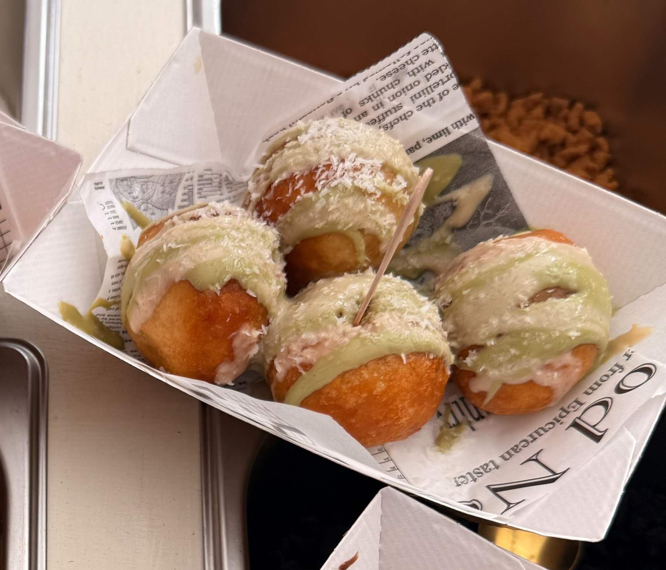 Mikatés nappés de crème pistache et de noix de coco râpée.