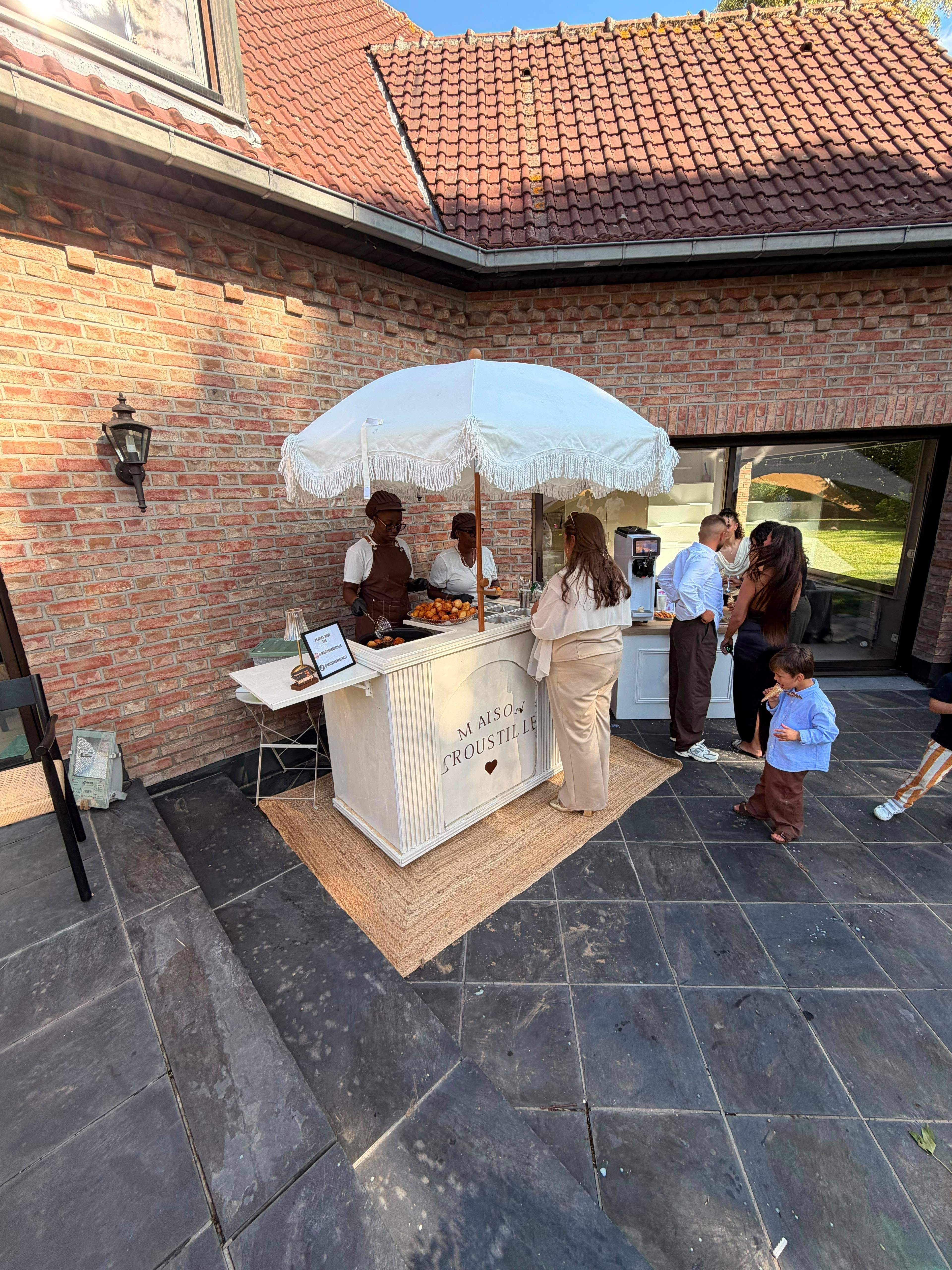 Le comptoir sur une terrasse en brique, entouré d’invités, pendant que nos hôtes servent les premiers cornets.